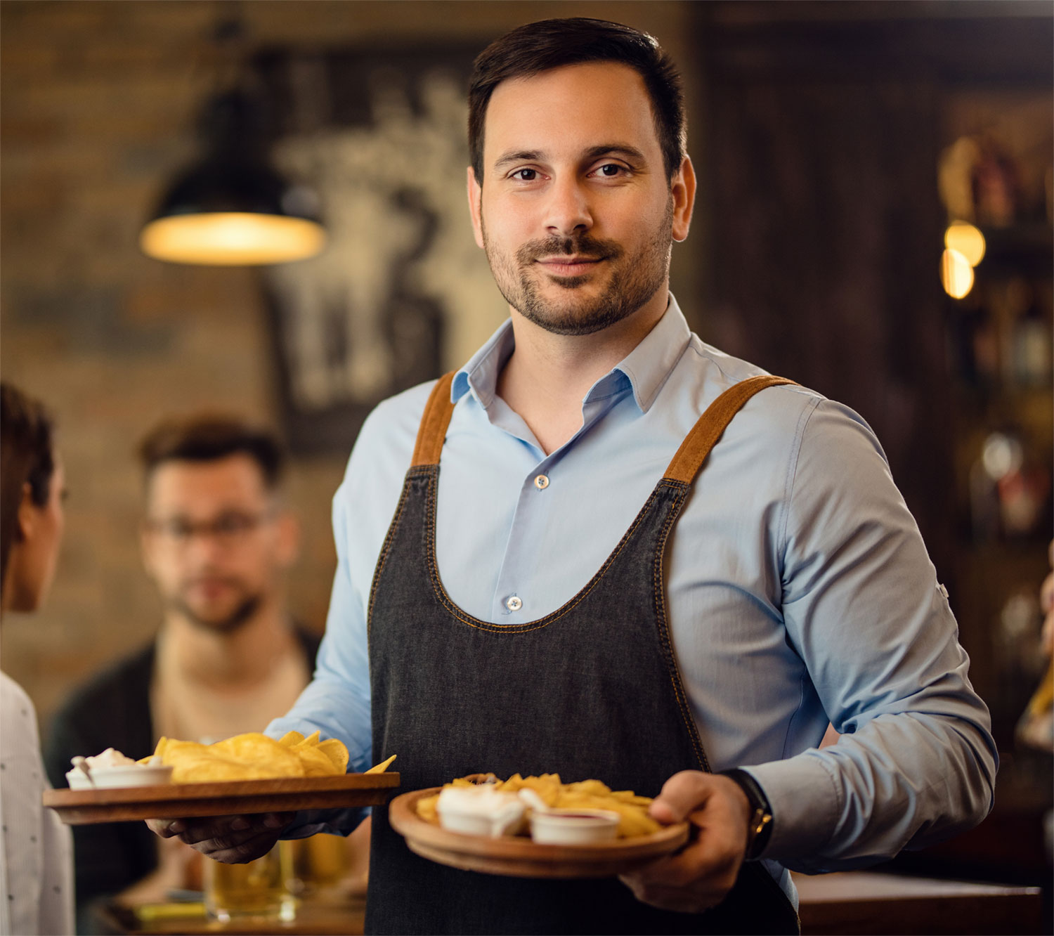 portrait-waiter-holding-plates-with-food-looking-camera-while-working-pub333
